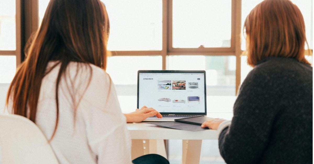 Duas mulheres escolhendo imagens em um notebook