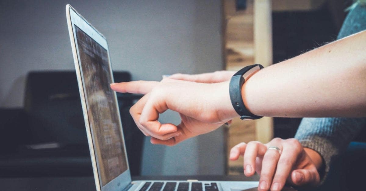 Mãos apontando para um notebook indicando como encontrar fornecedores dropshipping