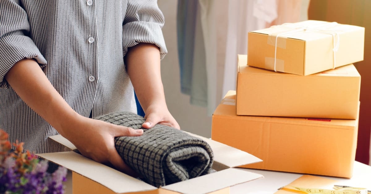 Mãos embalando pacotes de produtos para revender