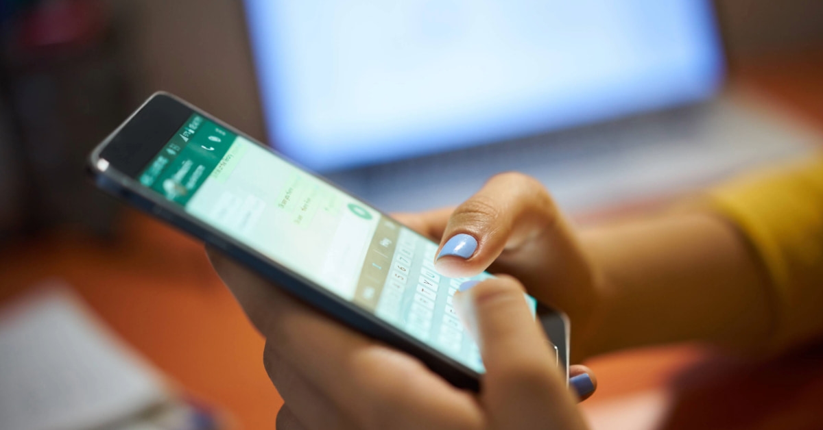 Mãos usando o smartphone para buscar frases para bio do WhatsApp