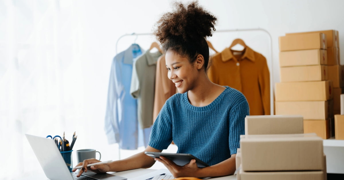 Mulher jovem sorridente em frente ao notebook aprendendo como abrir loja virtual para iniciantes