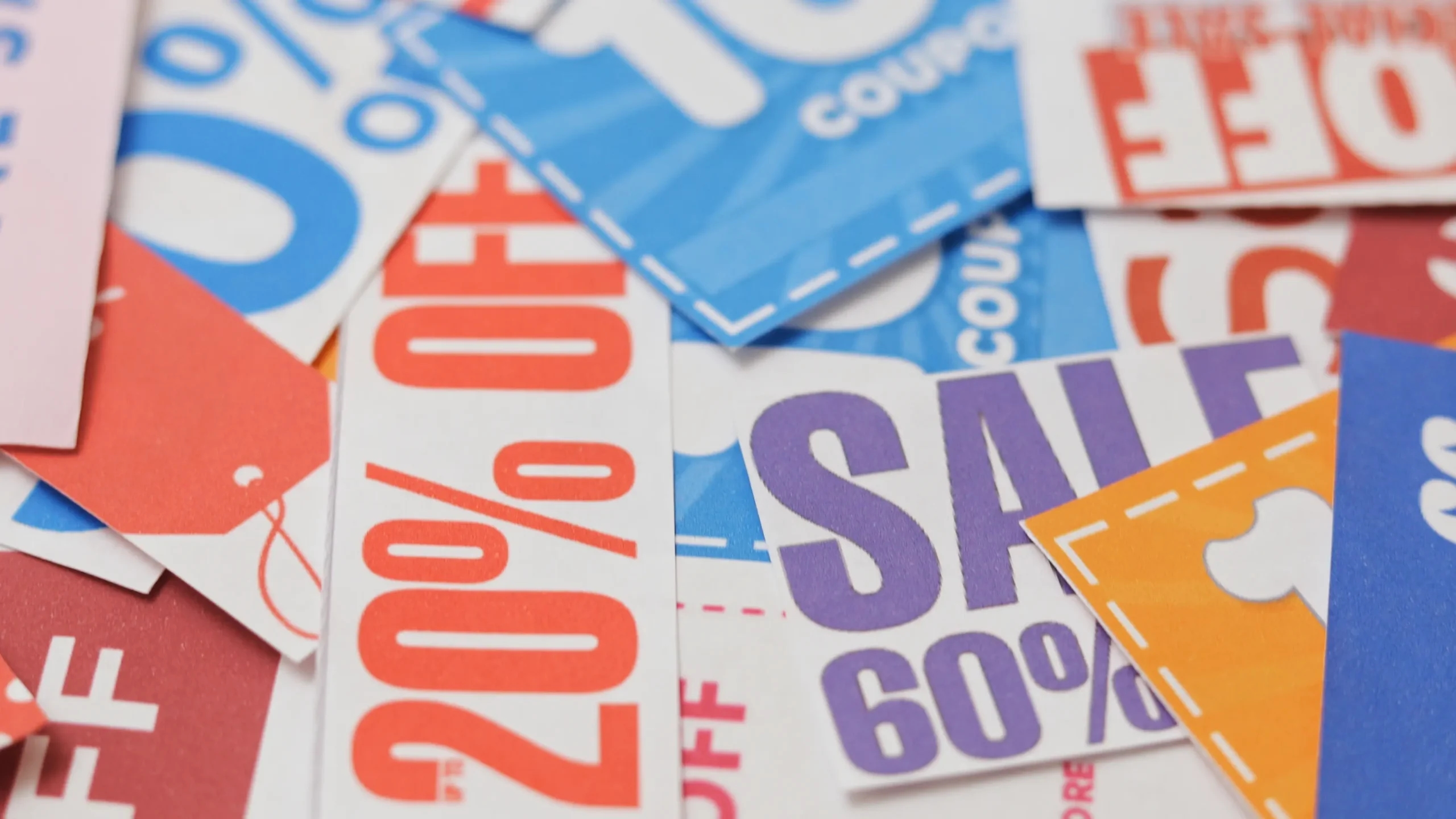 Cupons de desconto coloridos sobrepostos, com ofertas promocionais de até 60% e 20% de desconto. Copiar alt text