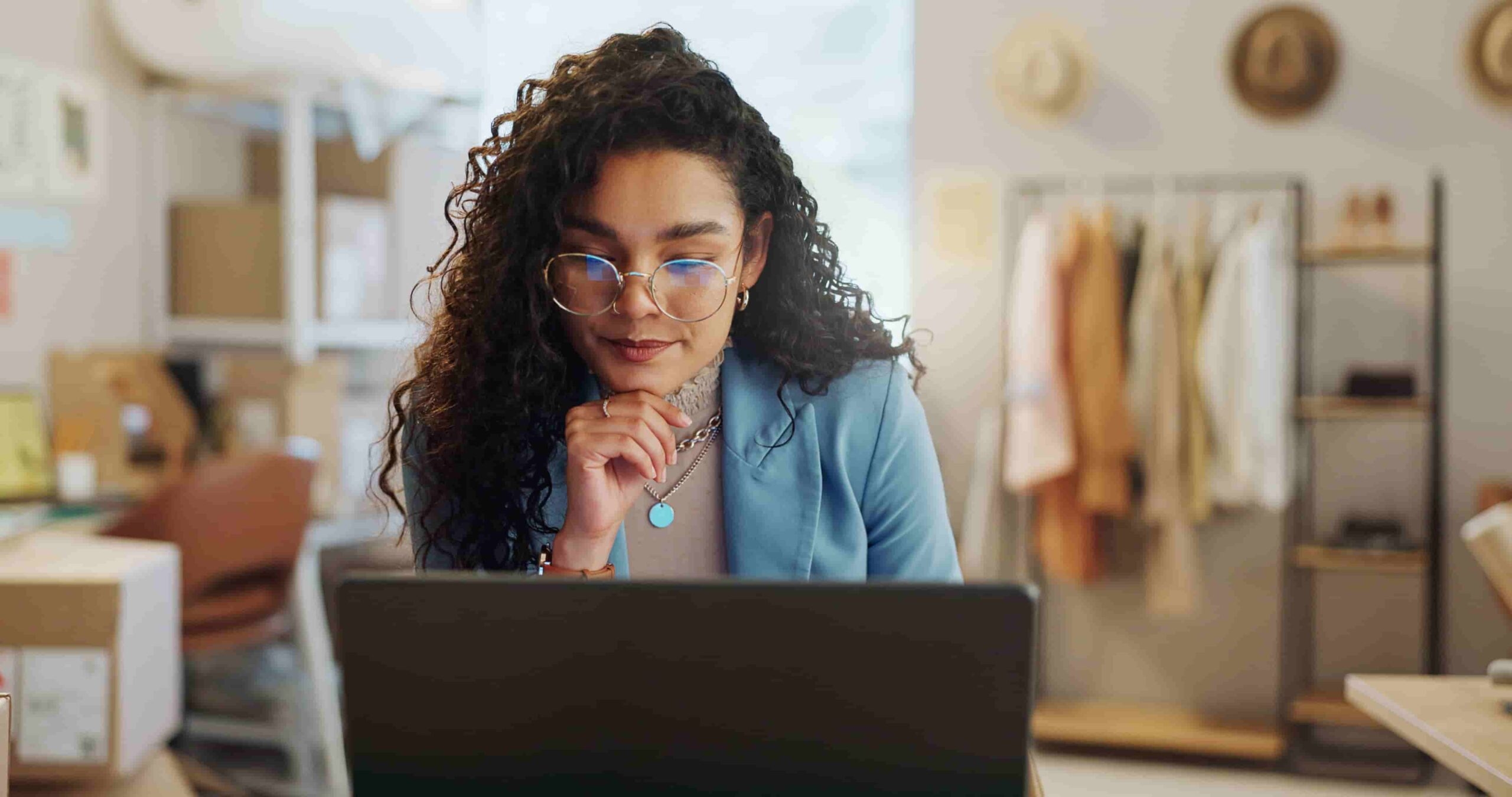 Mulher olhando para o notebook enquanto usa a planilha de contas a pagar