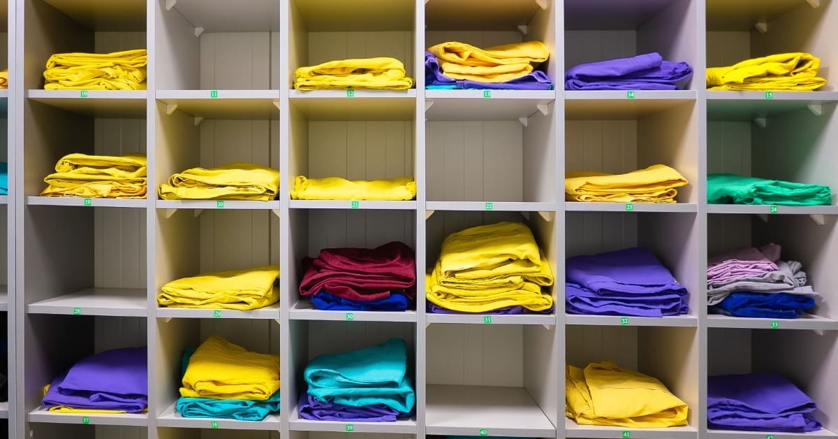 Estoque de roupas em prateleiras representando lista de fornecedores de roupas