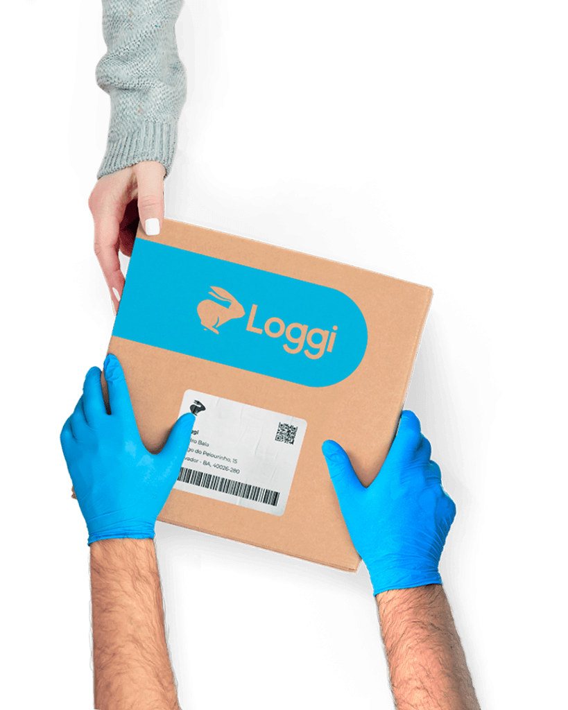 Mãos de um entregador parceiro, usando luvas azuis, entregando uma caixa parda da Loggi nas mãos de uma destinatária.