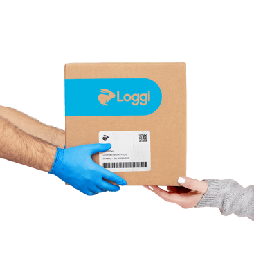 Mãos de um entregador parceiro, usando luvas azuis, entregando uma caixa parda da Loggi nas mãos de uma destinatária.