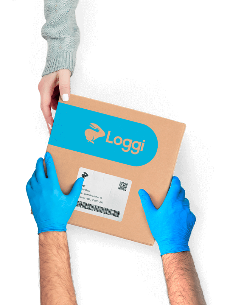 Mãos de um entregador parceiro, usando luvas azuis, entregando uma caixa parda da Loggi nas mãos de uma destinatária.