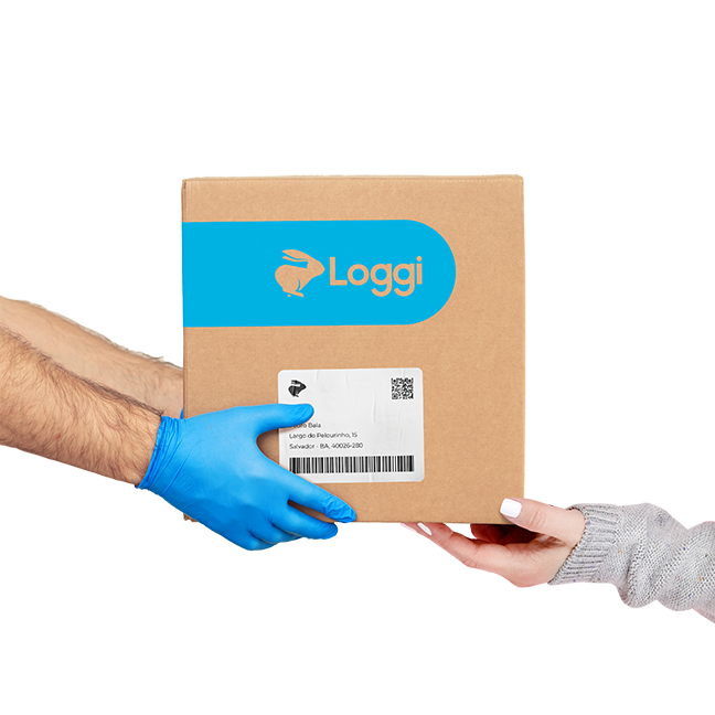 Mãos de um entregador parceiro, usando luvas azuis, entregando uma caixa parda da Loggi nas mãos de uma destinatária.